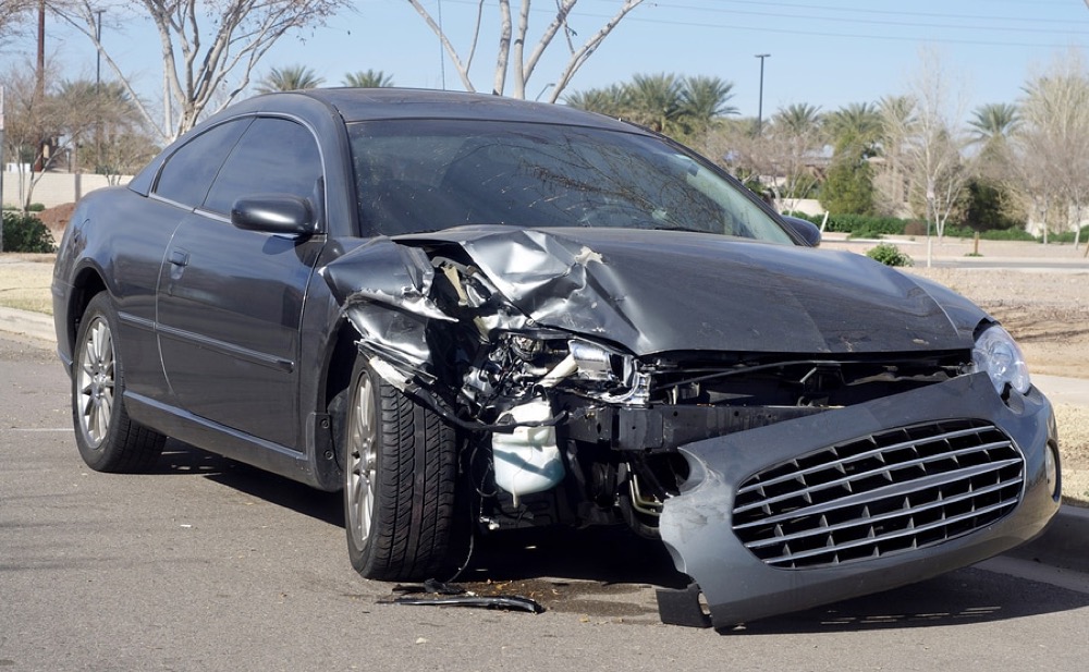 Gray coupe with heavy front-end damage after a collision